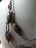 Soft fall- pink and purple with silver accents.  Multi-strand, easy clasp, comfortable necklace